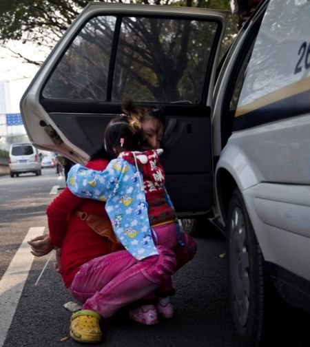 冲突发生后，女小贩的孩子惊恐地抱着被反绑的妈妈。 南都记者 黎湛均 摄